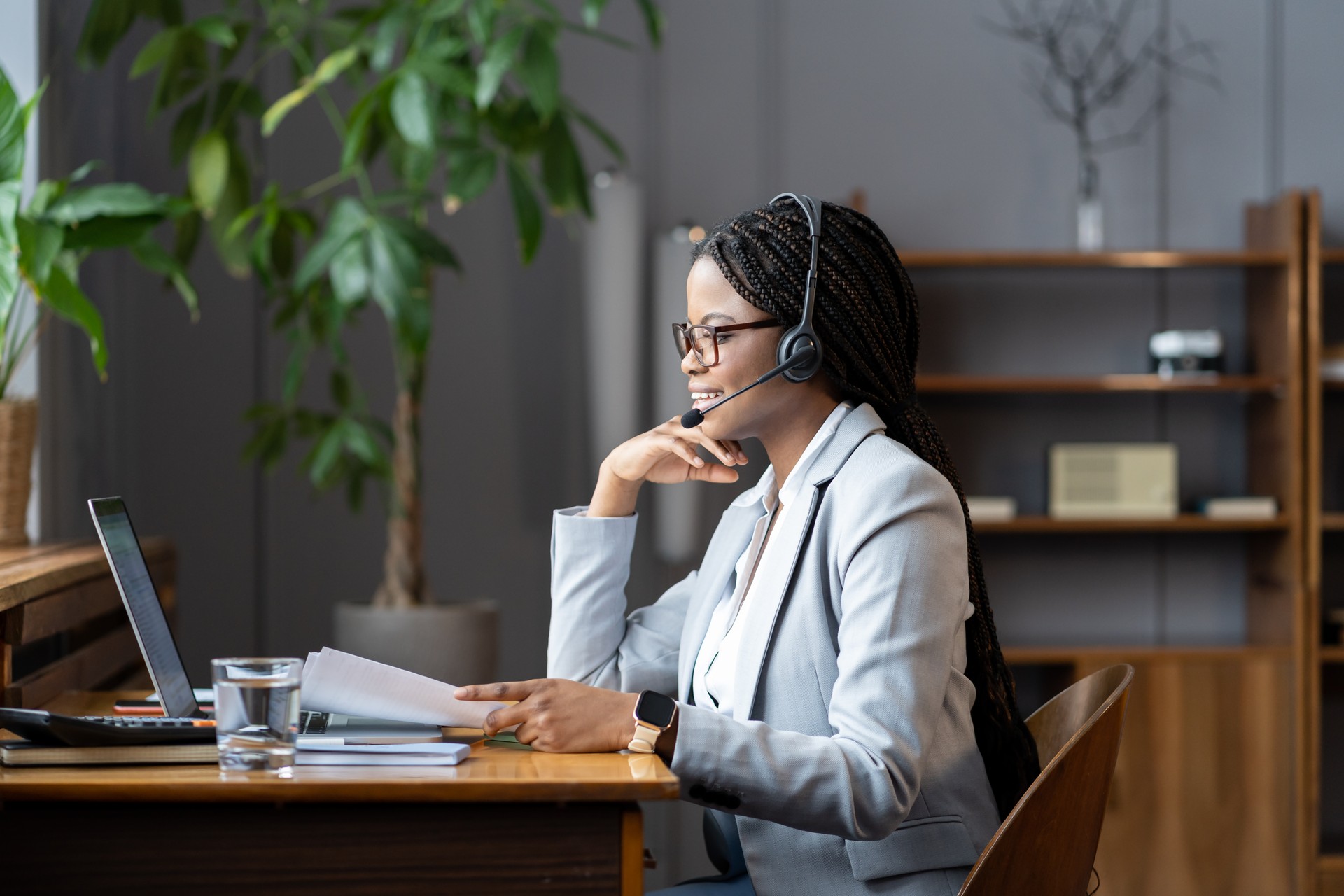 Young positive african woman remote recruiter using wireless headset to communicate with candidates